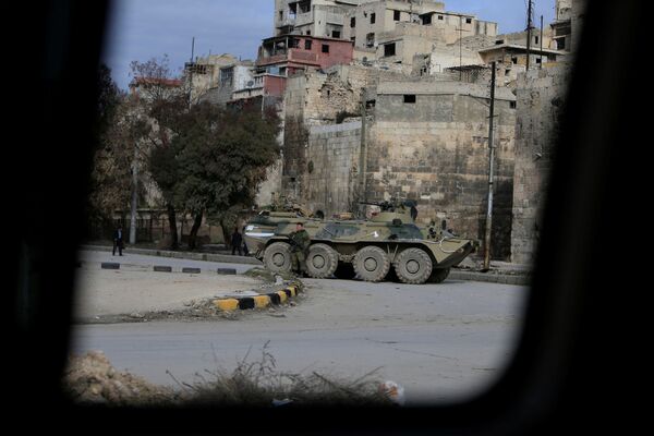 جندي روسي بالقرب من مدرعة في حلب، سوريا 30 يناير/ كانون الثاني 2017 - سبوتنيك عربي