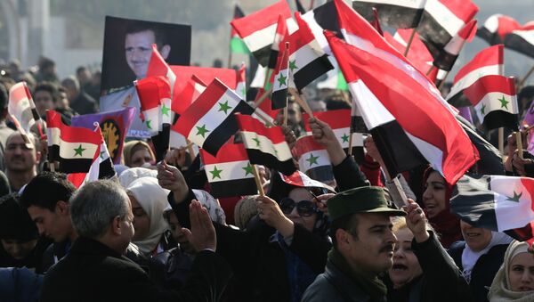 سوريون يحملون صور الرئيس بشار الأسد وأعلام سوريا في حلب - سبوتنيك عربي