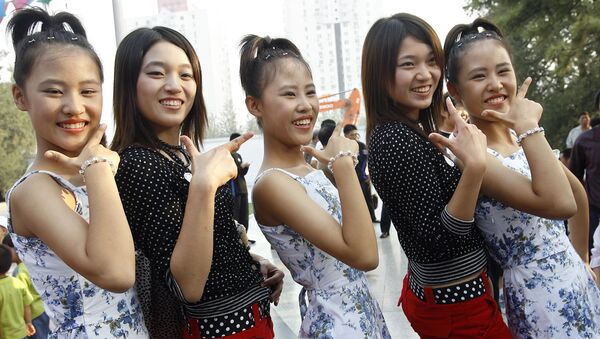 The Li sisters, a trio of 15-year-old triplets from Beijing pose for a photo with a pair of twins during the 2006 Beijing Twins Days Festival - سبوتنيك عربي
