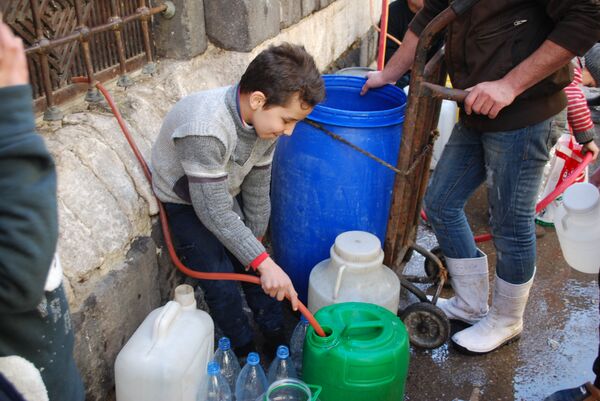 طفل يقوم بتعبئة الماء في دمشق طفل يقوم بتعبئة الماء في دمشق - سبوتنيك عربي