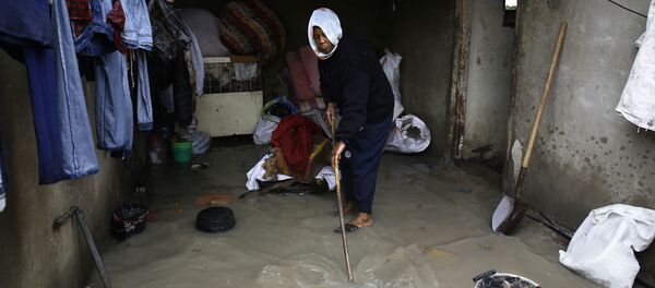 امرأة فلسطينية تقوم بتنظيف البيت من آثار فياضانات نتيجة أمطار غزيرة انهالت على مخيم جباليا، قطاع غزة، فلسطين 16 فبراير/ شباط 2017 - سبوتنيك عربي