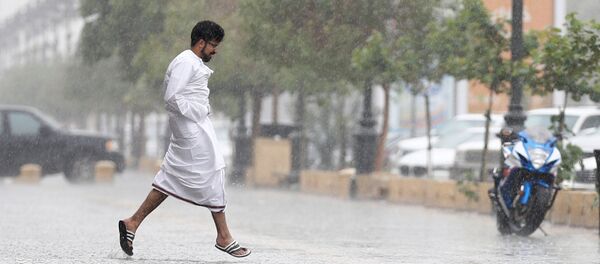 سعودي يجري بسبب الأمطار في العاصمة السعودية الرياض - سبوتنيك عربي