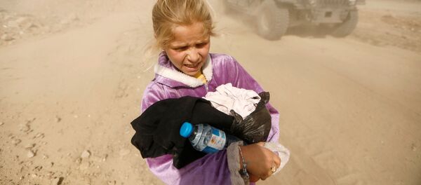 المواطنون العراقيون يهربون وأطفالهم من الموصل سيراً على الأقدام للوصول إلى حافلات الإجلاء في إربيل، 1 مارس/ آذار 2017 - سبوتنيك عربي