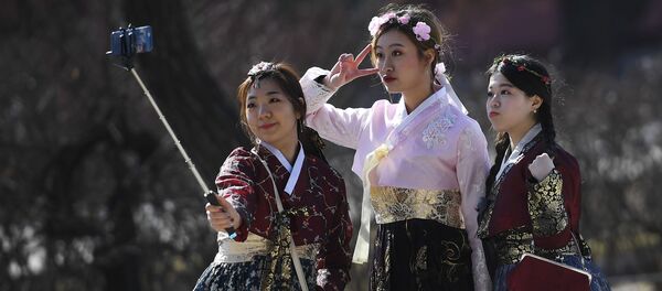 فتيات في سيؤول في زي تقليدي تلتقطن صور سيلفي من أمام قصر تشانغدوك في كوريا الجنوبية - سبوتنيك عربي