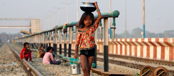 طفلة تحمل وعاء بعد تعبئته بالماء وتسير على السكة الحديدية، الهند 28 فبراير/ شباط 2017 - سبوتنيك عربي