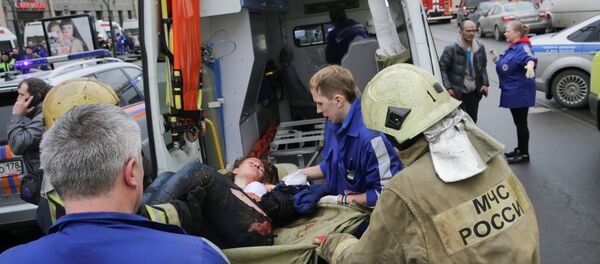 An injured person is helped by emergency services outside Sennaya Ploshchad metro station, following explosions in two train carriages at metro stations in St. Petersburg, Russia April 3, 2017 - سبوتنيك عربي