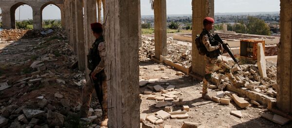 أمين مقداد يعزف على الكمان وسط ركام المباني في شرق مدينة الموصل، وذلك بعد أن كانت واقعة تحت سيطرة تنظيم داعش الإرهابي لمدة تزيد عن عامين ونصف، وعناصر الأمن العراقي تحرسه في جامع النبي يونس، العراق 19 أبريل/ نيسان 2017 - سبوتنيك عربي