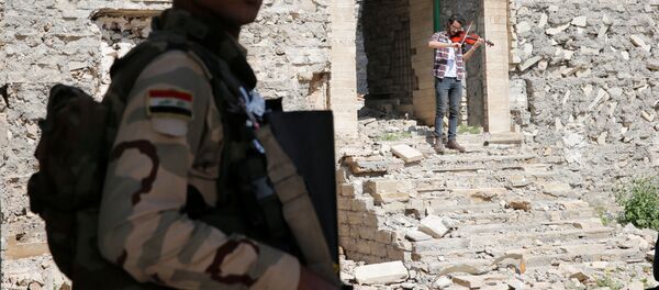 أمين مقداد يعزف على الكمان وسط ركام المباني في شرق مدينة الموصل، وذلك بعد أن كانت واقعة تحت سيطرة تنظيم داعش الإرهابي لمدة تزيد عن عامين ونصف، العراق 19 أبريل/ نيسان 2017 - سبوتنيك عربي