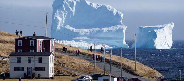 مواطنون كنديون يشاهدون عبور أول جبل جليدي يمر بمنطقة الساحل الجنوبي بالقرب من منطقة  فيريلاند نيوفاوندلاند، كندا 16 أبريل/ نيسان 2017 - سبوتنيك عربي