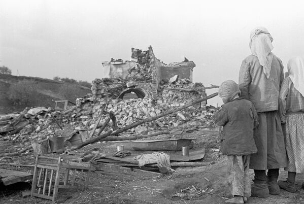 امرأة وأطفالها تنظر إلى ركام منزلهم، عام 1944 - سبوتنيك عربي