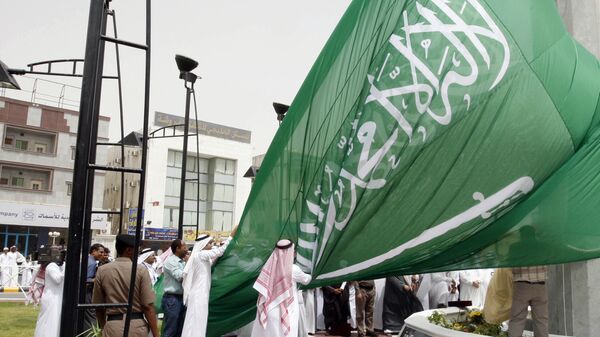 Saudi men unfurl a giant Saudi national flag during a ceremony to raise the highest flag in the country in the eastern city of Dammam on June 17, 2008 - سبوتنيك عربي