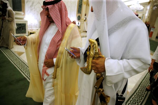 مسؤولان سعوديان يتفقدان الهاتف في أثناء زيارة ترامب - سبوتنيك عربي