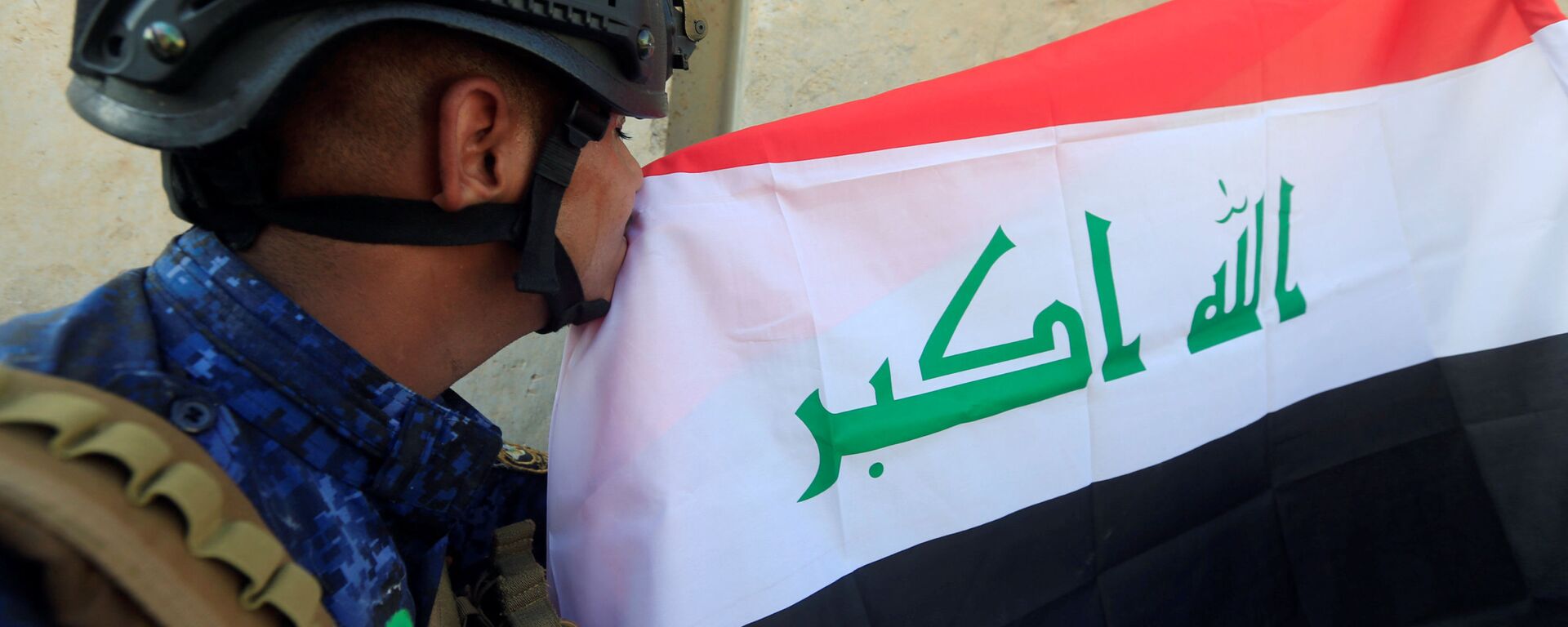 أحد عناصر الشرطة العراقية يقبل العلم العراقي بعد تحرير الموصل، العراق 9 يوليو/ تموز 2017 - سبوتنيك عربي, 1920, 09.03.2022