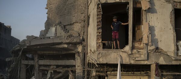 ضابط في الشرطة العراقية يقف داخل مبنى مدمر في مدينة الموصل، العراق 9  يوليو/ تموز 2017 - سبوتنيك عربي