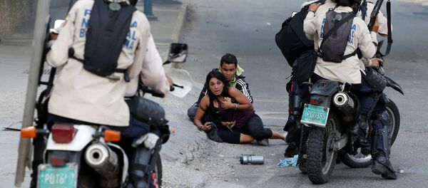 مصابان من أنصار المعارضة إثر استخدام الشرطة لرذاذ الفلفل في كاراكاس، فنزويلا 9 يوليو/ تموز 2017 - سبوتنيك عربي