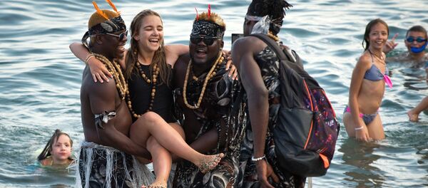 السياحة في القرم - فتاة أثناء التصوير مع سياح أجانب على شاطئ سوداكو - سبوتنيك عربي