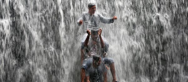 شبان يقفون بالقرب من سد ملئ بمياه بحيرة بوفاي، بعد أمطار غزيرة في مومباي، الهند 20 يوليو/ تموز 2017 - سبوتنيك عربي