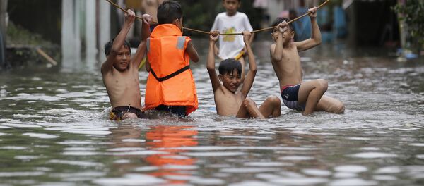 فتيان يلعبون خارج منازلهم المغمورة إثر الأمطار الغزيرة التي سببتها العاصفة الاستوائية نيسات أجزاء من مانيلا الكبرى، الفلبين 27 يوليو/ تموز 2017 فتيان يلعبون خارج منازلهم المغمورة إثر الأمطار الغزيرة التي سببتها العاصفة الاستوائية نيسات أجزاء من مانيلا الكبرى، الفلبين 27 يوليو/ تموز 2017 - سبوتنيك عربي