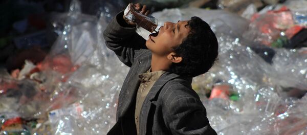 طفل يمني يأكل من بقايا القمامة في صنعاء، اليمن - سبوتنيك عربي