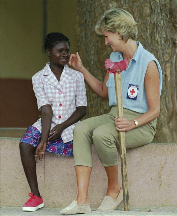 الأميرة ديانا تتحدث إلى فتاة الـ 13 عاما، ساندرا ثيجيكا، التي فقدت أحد قدميها في حقل زرعت في الألغام بساوريمو، شرق أنغولا، عام 1994 - سبوتنيك عربي