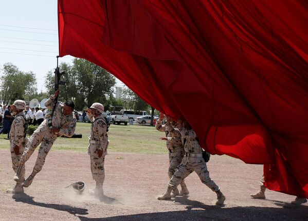 جندي وبندقيته يتعلقان بعلم عملاق عن طريق الخطأ خلال التحضيرات للاحتفال بالذكرى الـ 207 لاستقلال المكسيك عن إسبانيا، والتي تصادف يوم 16 سبتمبر/ أيلول في سيوداد خواريز، المكسيك في 4 سبتمبر/ أيلول 2017 - سبوتنيك عربي