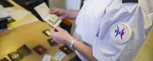 شرطي فرنسي يتفقد جوازات السفر المزورة - سبوتنيك عربي