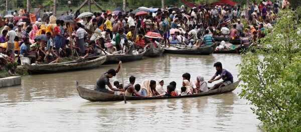 A boat carrying Rohingya refugees is seen leaving Myanmar through Naf river while thousands other waiting in Maungdaw, Myanmar, September 7, 2017 - سبوتنيك عربي