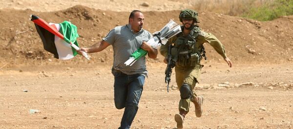 جندي إسرائيلي يركض خلف متظاهر فلسطيني خلال الاشتباكات دارت بين المتظاهرين والجيش الإسرائيلي في بلدة طوباس بالضفة الغربية، فلسطين 27 سبتمبر/ أيلول 2017 - سبوتنيك عربي