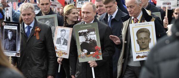 الرئيس فلاديمير بوتين أثناء مشاركته المواطنين لمسيرة الفوج الخالد في الذكرى الـ 72 لعيد النصر في الحرب الوطنية العظمى على الساحة الحمراء في موسكو، روسيا 9 مايو/ أيار 2017 - سبوتنيك عربي