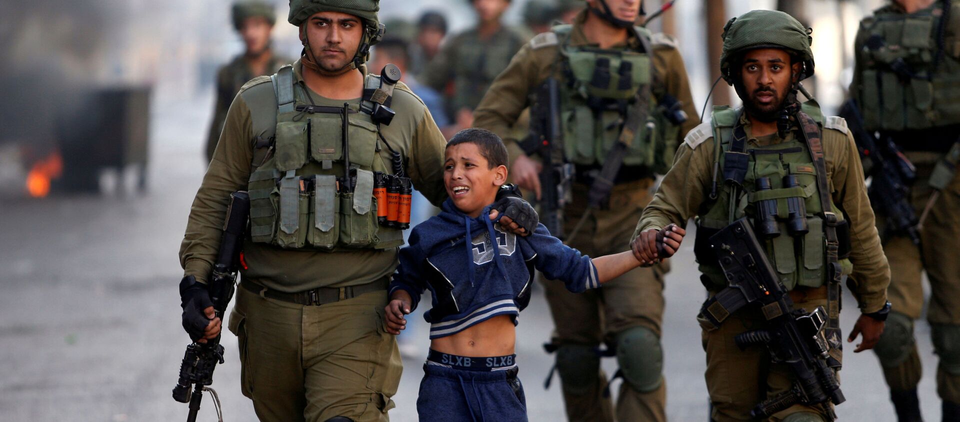 جنود إسرائيليون يعتقلون طفلا فلسطينيا خلال اشتباكات في الخليل، الضفة الغربية، 13 أكتوبر/ تشرين الأول 2017 - سبوتنيك عربي, 1920, 20.06.2021