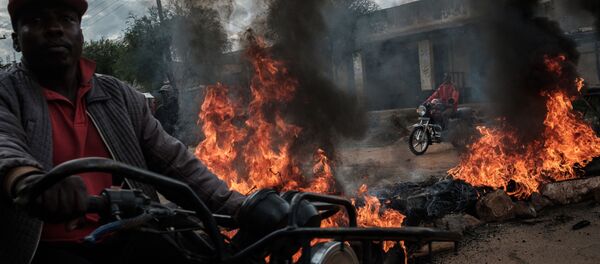 سائقو سيارات الأجرة يقودون سياراتهم وسط حواجز مشتعلة أقامها أنصار المرشح الرئاسي رايلا أودينغو، خلال احتجاجات في ماجينغو، كينيا 28 أكتوبر/ تشرين الأول 2017 - سبوتنيك عربي