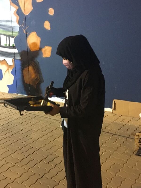 الفنانة نورة السعودية بن سعيدان خلال رسم جدارية للجندي السعودي - سبوتنيك عربي