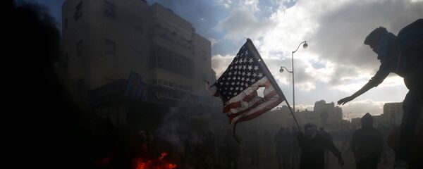 متظاهرون فلسطينيون يحرقون العلم الأمريكي احتجاجا على قرار الرئيس دونالد ترامب بشأن القدس، بالقرب من مستوطنة إسرائيلية في بيت إيل، الضفة الغربية، 7 ديسمبر/ كانون الأول 2017 - سبوتنيك عربي
