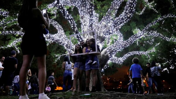 عائلة تلتقط صورة داخل إطار على خلفية شجرة الكريسماس في سان باولو، البرازيل 3 ديسمبر/ كانون الأول 2017 - سبوتنيك عربي