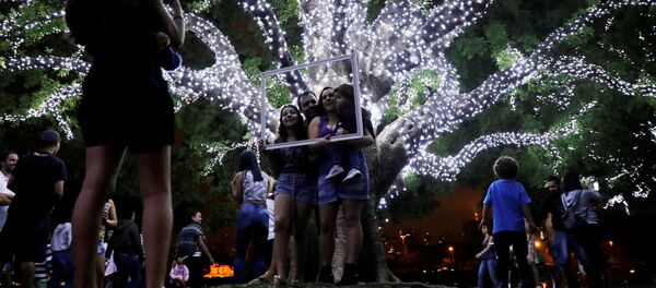 عائلة تلتقط صورة داخل إطار على خلفية شجرة الكريسماس في سان باولو، البرازيل 3 ديسمبر/ كانون الأول 2017 - سبوتنيك عربي