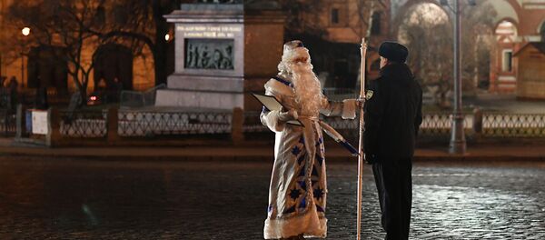 بابا نويل الذي أحضر الشجرة الرئيسية لرأس السنة الجديدة وينتظر الدخول خلال أبواب برج سباسكي إلى ساحة الكرملين، موسكو - سبوتنيك عربي