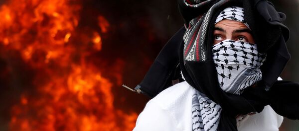 متظاهر فلسطيني ضد قرار الرئيس دونالد ترامب بإعلان مدينة القدس عاصمة لإسرائيل، بالقرب من حاجز قلنديا بالقرب من رام الله، الضفة الغربية، فلسطين 20 ديسمبر/ كانون الأول 2017 - سبوتنيك عربي