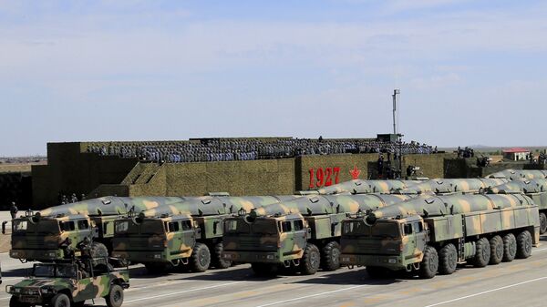 In this photo released by China's Xinhua News Agency, military vehicles carrying missiles for both nuclear and conventional strikes are driven past the VIP stage during a military parade to commemorate the 90th anniversary of the founding of the People's Liberation Army at Zhurihe training base in north China's Inner Mongolia Autonomous Region, Sunday, July 30, 2017 - سبوتنيك عربي