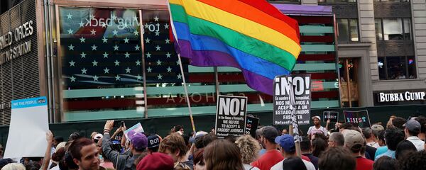 علم قوس قزح يرفرف بينما يحتج الناس على حظر الرئيس الأمريكي دونالد ترامب لأشخاص متحولين جنسيا من الخدمة في الجيش الأمريكي في نيويورك - سبوتنيك عربي