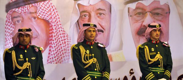 الحرس الملكي السعودي وفي الخلفية صورة للملك عبد الله بن عبد العزيز والملك سلمان بن عبد العزيز والأمير مقرن بن عبد العزيز - سبوتنيك عربي