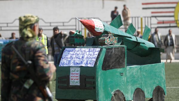جندي من أنصار الله يقف أمام نموذج كرتون لصاروخ خلال تجمع بمناسبة 1000 يوم من التدخل العسكري بقيادة السعودية في الصراع اليمني - سبوتنيك عربي