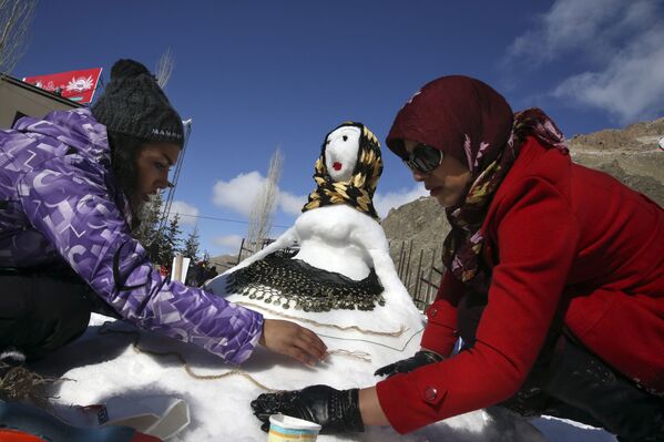 نساء يصنعون تماثيلا من الثلج أثناء مهرجان رجل الثلج في إيران - سبوتنيك عربي