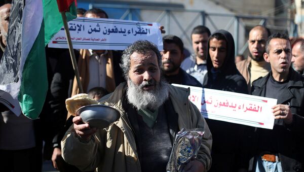 فلسطينيون يشاركون في احتجاجات تدعو إلى تحسين الظروف المعيشية للناس خارج مكتب الأونروا في رفح جنوب قطاع غزة - سبوتنيك عربي