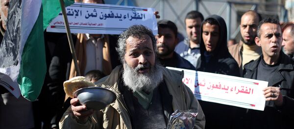 فلسطينيون يشاركون في احتجاجات تدعو إلى تحسين الظروف المعيشية للناس خارج مكتب الأونروا في رفح جنوب قطاع غزة - سبوتنيك عربي