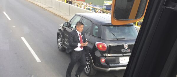 رجل يندفع حول السيارة التي تحمل البابا فرانسيس، بعد أن توقفت على الطريق مع الإطارات المسطحة، في الطريق إلى قصر الحكومة في ليما، بيرو، الجمعة، 19 يناير/كانون الثاني 2018. - سبوتنيك عربي