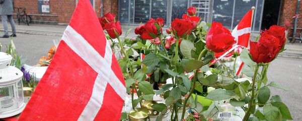 A Danish flag and roses are placed in front of a cultural club in Copenhagen, Denmark, Tuesday, Feb. 17, 2015. - سبوتنيك عربي