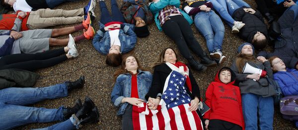 طلبة يستلقون أمام البيت الأبيض في العاصمة الأمريكية واشنطن الاثنين 19 فبراير/شباط 2018 لمطالبة الحكومة بإجراء تغييرات في قوانين الأسلحة بعد حادث هجوم مدرسة مارجوري ستونيمان دوغلاس - سبوتنيك عربي