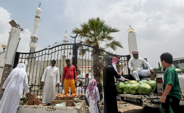 رجال يتبضعون في كشك للفواكه خارج مسجد في مدينة الطائف، السعودية في 28 يوليو/ تموز 2017 - سبوتنيك عربي