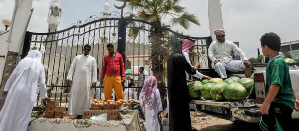 رجال يتبضعون في كشك للفواكه خارج مسجد في مدينة الطائف، السعودية في 28 يوليو/ تموز 2017 - سبوتنيك عربي
