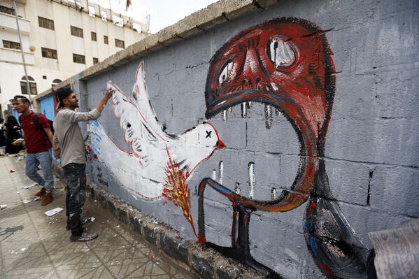 فنان يمني يرسم لوحة غرافيتي على الجدران لدعم السلام، في إطار حملة يوم مفتوح للفن في العصامة صنعاء، اليمن 15 مارس/ آذار 2018 - سبوتنيك عربي